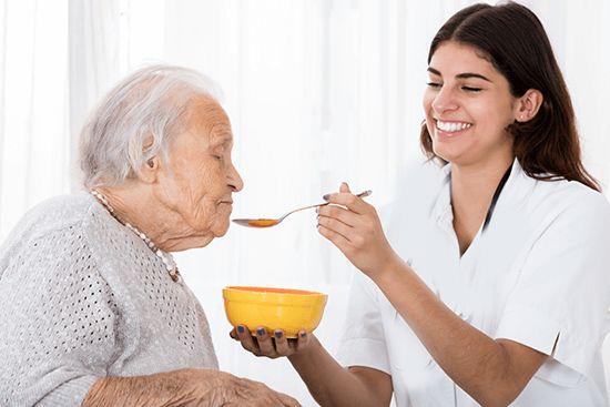 Healthcare professional assisting an elderly person at home