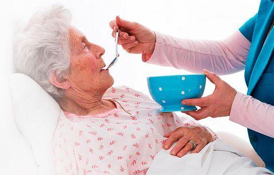 Healthcare professional assisting an elderly person at home